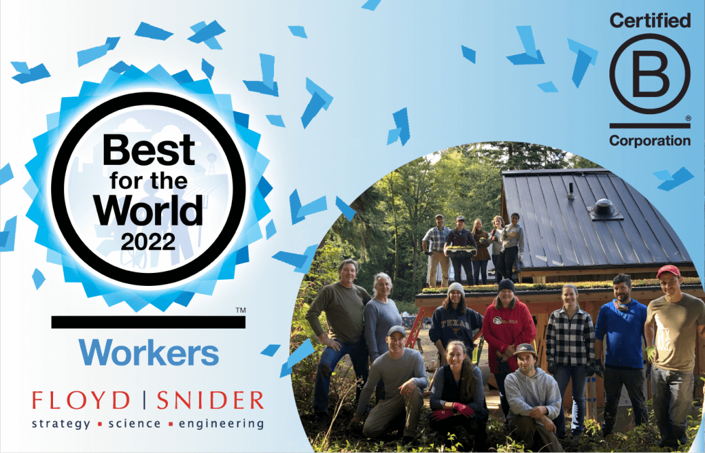 Graphic with blue background and confetti. B Corp Logo is in the rop right, FLoydsnider logo in the bottom left, and a photo of a group of people posing in front of a building fills the right side of the image. Text reads Best for the World 2022 Workers.